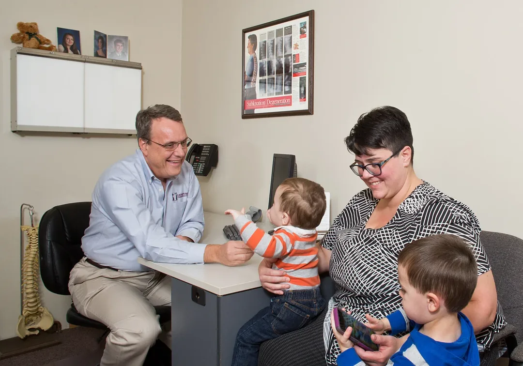 Dr. James T. Lefebvre speaking with a family in the office